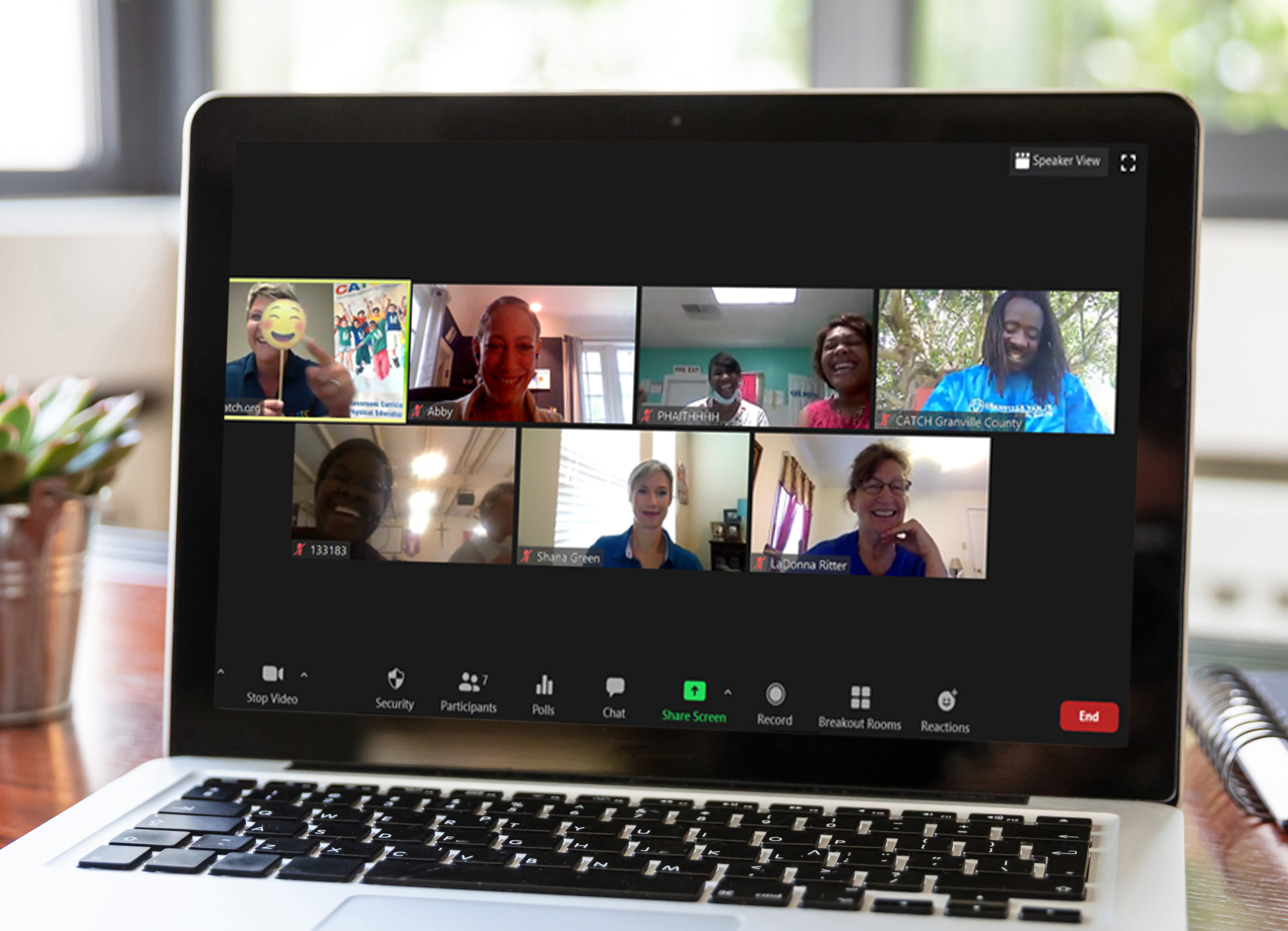 Laptop with white blank screen on a wooden desk