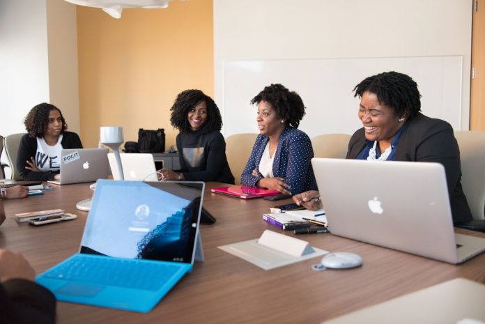 office A group of professionals using a knowledge management tool to enhance collaboration and knowledge sharing, working seamlessly on projects through a sophisticated platform with real-time communication features.